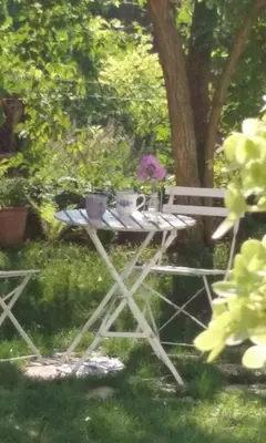 a picnic table with flowers and a bench in the grass at Leśna 6 - House with a garden in Bolechowice