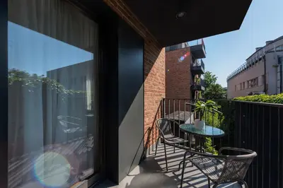 a patio with two chairs and a table on a balcony at Old Town Luxury Apartments in Kraków