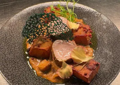 a plate of food with meat and vegetables on a table at Hotel Imperiale in Oświęcim