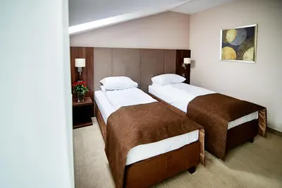 a room with two beds in a hotel room at Hotel Imperiale in Oświęcim