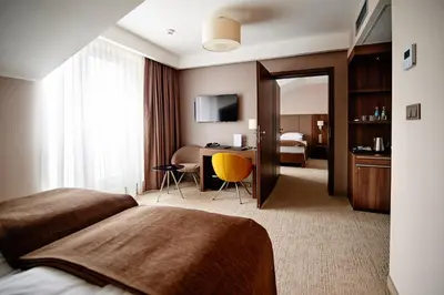 a hotel room with two beds and a desk at Hotel Imperiale in Oświęcim