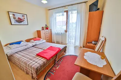 a bedroom with a bed and a desk and a table at Ośrodek Wczasowy Sokół in Rabka