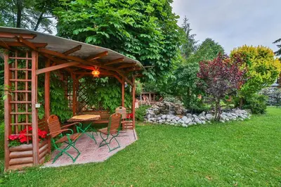 a wooden gazebo with a table and chairs in a yard at Ośrodek Wczasowy Sokół in Rabka