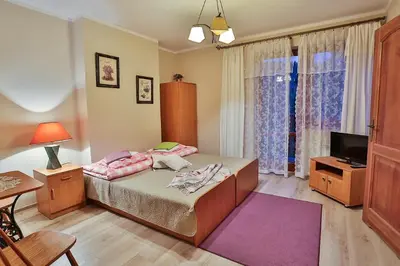 a bedroom with a bed and a desk and a television at Ośrodek Wczasowy Sokół in Rabka