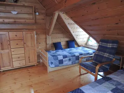 a bedroom with a bed and a chair in a cabin at Apartament Suzyw Kicek in Sucha Beskidzka