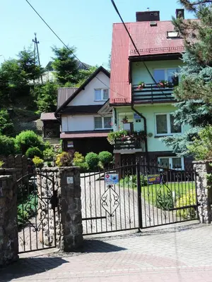 a black fence in front of a house at Apartament Suzyw Kicek in Sucha Beskidzka