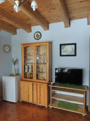 a living room with a television and a wooden cabinet at Apartament Suzyw Kicek in Sucha Beskidzka