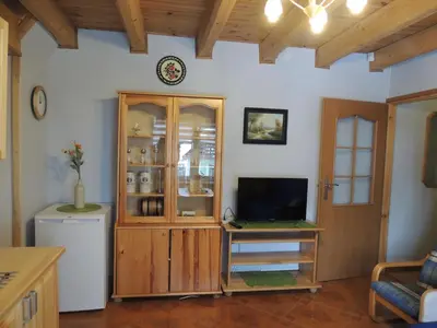 a living room with a tv and a cabinet at Apartament Suzyw Kicek in Sucha Beskidzka