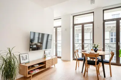 a dining room with a table and a tv on a wall at Quiet Luxury Hideaway in Kraków