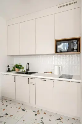 a white kitchen with a sink and a microwave at Quiet Luxury Hideaway in Kraków