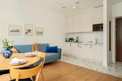 a living room with a table and a blue couch at Quiet Luxury Hideaway in Kraków
