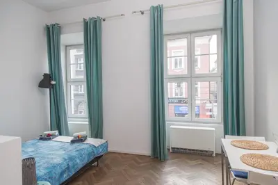 a bedroom with green curtains and a bed and a window at Venice Lagoon Apartment in Kraków