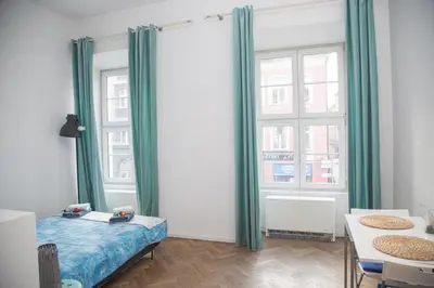 a bedroom with green curtains and a bed and a table at Venice Lagoon Apartment in Kraków