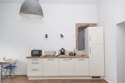 a kitchen with white cabinets and a white refrigerator at Venice Lagoon Apartment in Kraków