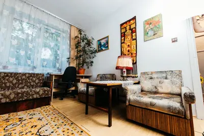 a living room with a couch and a table and chairs at Feel The Old Socialist Style Apartment in Kraków