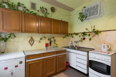 a kitchen with wooden cabinets and a white stove top oven at Feel The Old Socialist Style Apartment in Kraków