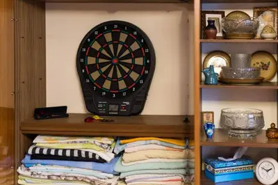 a dart board on a wall next to a shelf at Feel The Old Socialist Style Apartment in Kraków