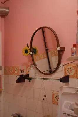 a bathroom with a mirror on a pink wall at Feel The Old Socialist Style Apartment in Kraków