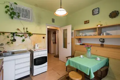 a kitchen with a table with a vase of flowers on it at Feel The Old Socialist Style Apartment in Kraków