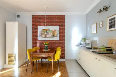 a kitchen and dining room with a table and yellow chairs at Smile Apartments Center Kraków Old Town in Kraków