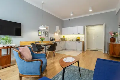 a kitchen and living room with a table and chairs at Smile Apartments Center Kraków Old Town in Kraków