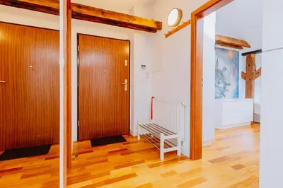 a hallway with a wooden door and a wooden floor at Atticus Apartments in Kraków