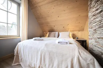 a bedroom with a bed with two towels on it at Domek nad Potokiem in Nowy Targ