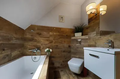 a bathroom with a tub and a toilet and a sink at Domek nad Potokiem in Nowy Targ