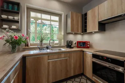 a kitchen with wooden cabinets and a sink and a window at Domek nad Potokiem in Nowy Targ