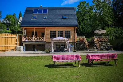 two benches in a yard in front of a house at Domek nad Potokiem in Nowy Targ