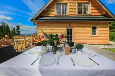 a table with white plates and flowers on a house at Domek nad Potokiem in Nowy Targ