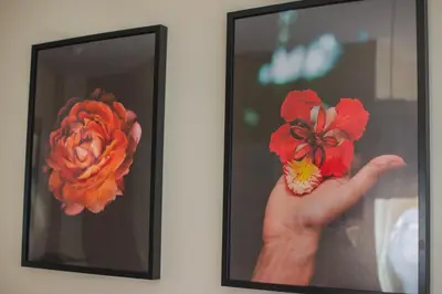 a person holding two red flowers in a picture at Garden Apartment in Kraków