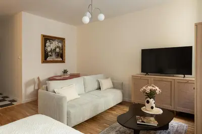 a table in a living room with a table and two chairs at Prestigious Main Square Apartment in Kraków