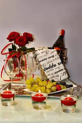 a table with a bottle of wine and a plate of grapes at Jacuzzi Apartment Zen in Kraków