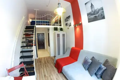 a living room with a couch and a staircase at Apartment Brzozowa in Kraków