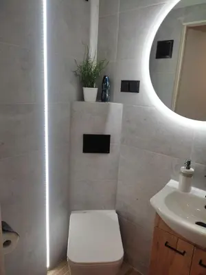a bathroom with a toilet and a sink and a mirror at Apartment Brzozowa in Kraków