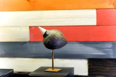 a black bird figurine on a table with a flag at Apartment Brzozowa in Kraków