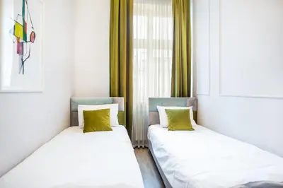 two beds sitting next to a window in a room at Cracow Rentals Zacisze in Kraków
