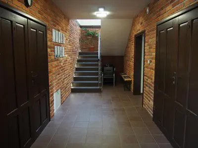 a hallway with a staircase and a brick wall at Eko Dom Eturia in Suchoraba