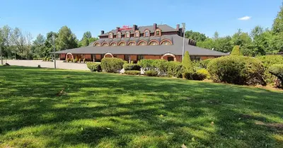 a large building with a green lawn in front of it at Hotel Zajazd Celtycki in Zakrzów