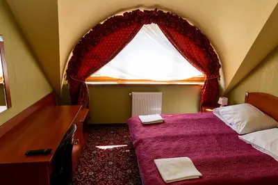 a bedroom with a bed and a window with curtains at Hotel Zajazd Celtycki in Zakrzów