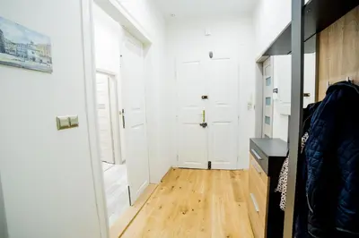 a hallway with a white door and a wooden floor at Market Square Residence in Kraków