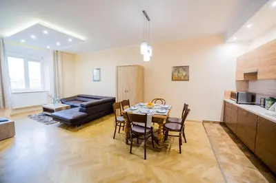a kitchen and living room with a table and chairs at Market Square Residence in Kraków