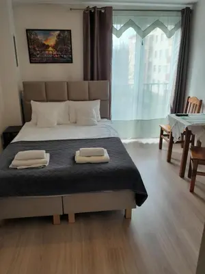 a bedroom with a bed with two towels on it at Królewski Apartament in Kraków