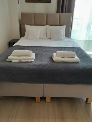 a bed with two towels on top of it at Królewski Apartament in Kraków