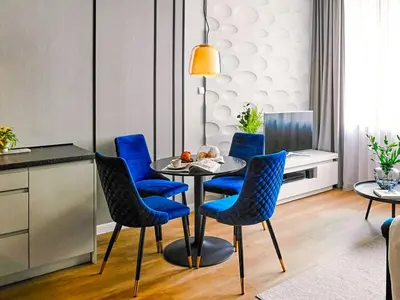 a dining room with blue chairs and a table at Wielopole17 Max Apartment with AC in Kraków
