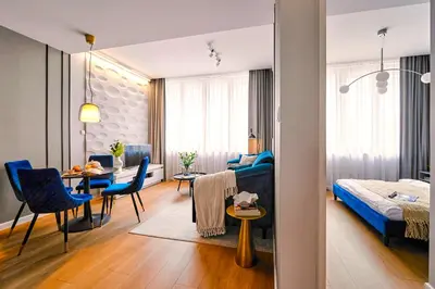 a living room with a bed and a dining room at Wielopole17 Max Apartment with AC in Kraków