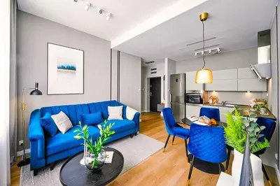 a living room with a blue couch and a table at Wielopole17 Max Apartment with AC in Kraków