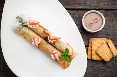 a white plate with two pieces of food on a table at Royal Residence by OTR in Kraków