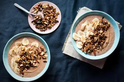 three bowls of oatmeal with bananas and nuts on a table at Royal Residence by OTR in Kraków
